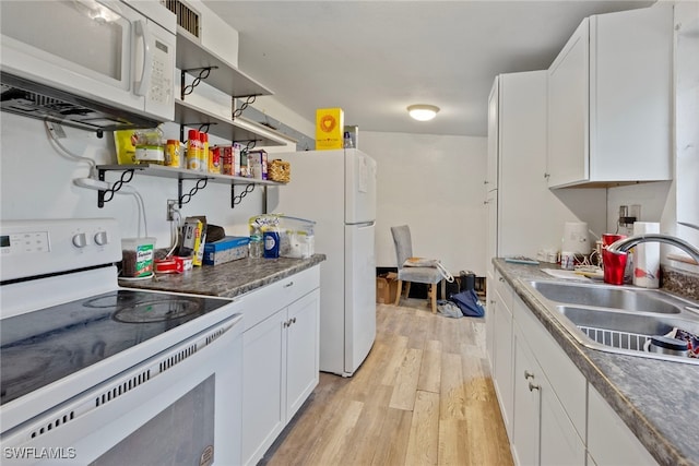 kitchen featuring white appliances, light hardwood / wood-style floors, sink, and white cabinets