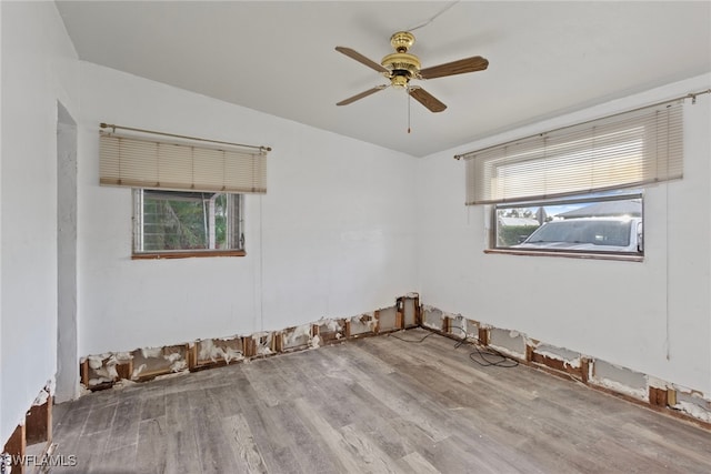 empty room with light hardwood / wood-style floors, a healthy amount of sunlight, and ceiling fan