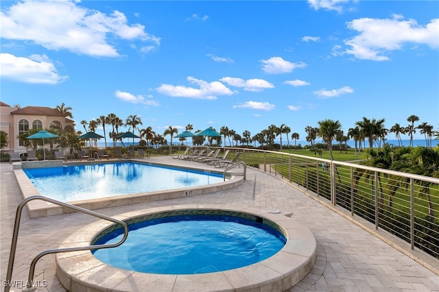 view of pool with a patio area and a hot tub