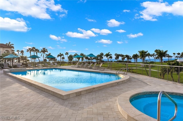 view of swimming pool featuring a patio area and a hot tub