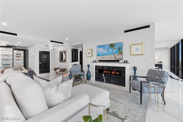 living room featuring built in shelves and a high end fireplace