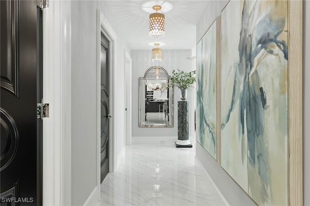 3971 Gulf Shore Blvd N Unit 1505, Naples, FL 34103 - corridor with marble tiled floors, a chandelier, and baseboards