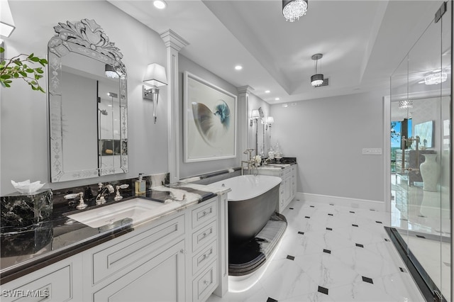 bathroom with ornate columns, vanity, a raised ceiling, and separate shower and tub