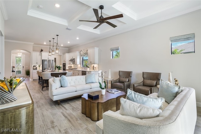 living room featuring coffered ceiling, a wealth of natural light, and ornamental molding