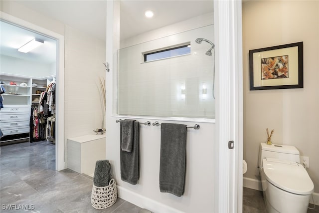 bathroom featuring toilet and tiled shower