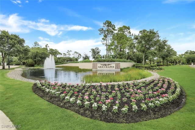 surrounding community featuring a water view and a lawn