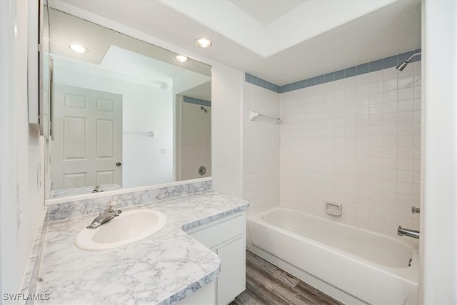 bathroom featuring vanity, hardwood / wood-style floors, and tiled shower / bath combo