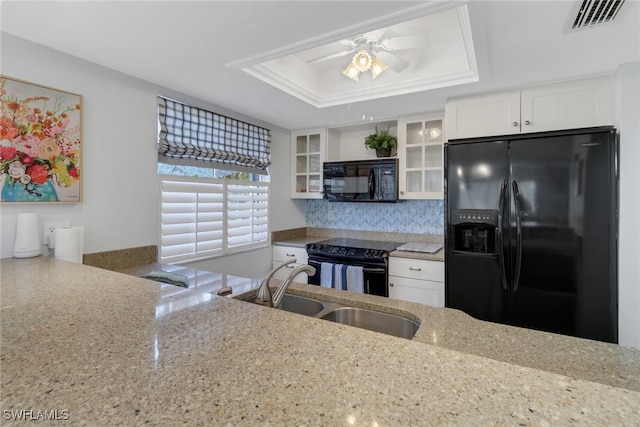 kitchen featuring white cabinets, a tray ceiling, black appliances, and sink