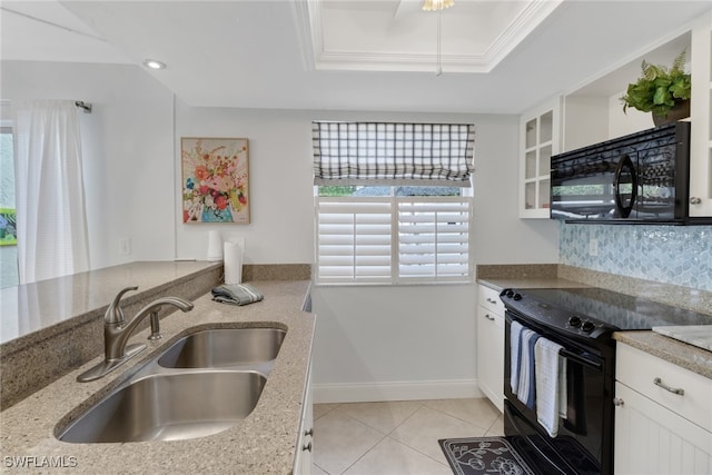 kitchen with light stone countertops, black appliances, sink, white cabinets, and light tile patterned floors