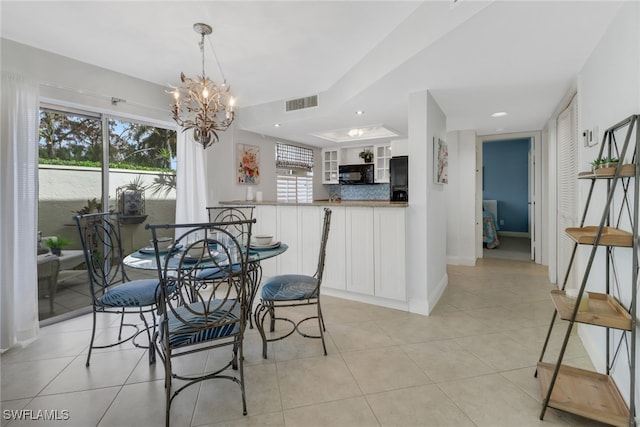 tiled dining room with a notable chandelier