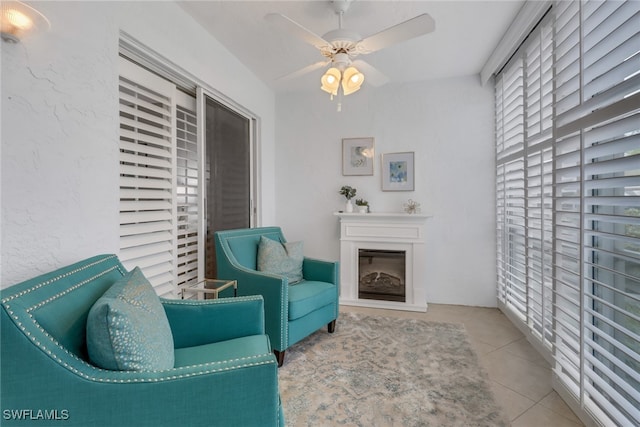 sitting room with ceiling fan and light tile patterned flooring