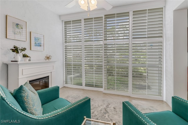 living area featuring ceiling fan, light tile patterned floors, and plenty of natural light