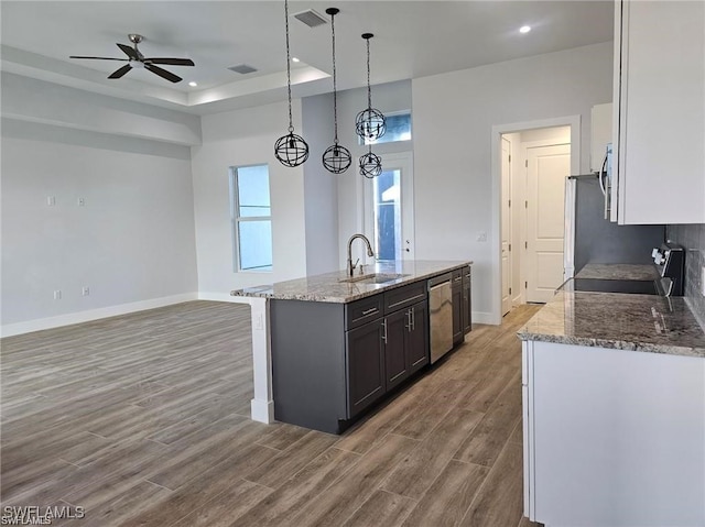 kitchen with wood-type flooring, sink, appliances with stainless steel finishes, dark brown cabinetry, and decorative light fixtures