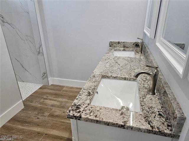 bathroom featuring vanity, a tile shower, and hardwood / wood-style flooring