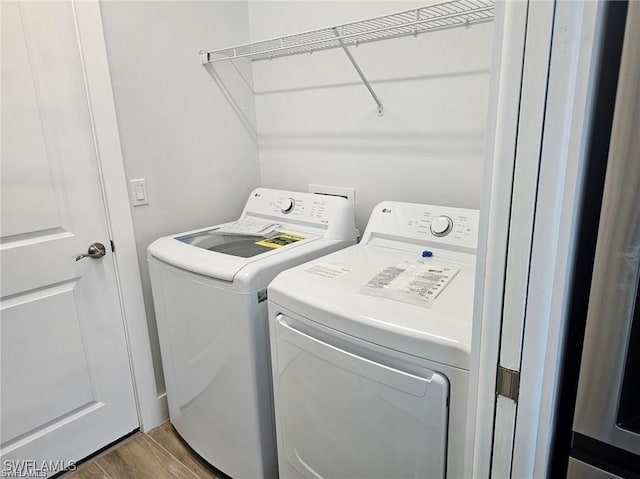 laundry room featuring washer and clothes dryer and hardwood / wood-style flooring