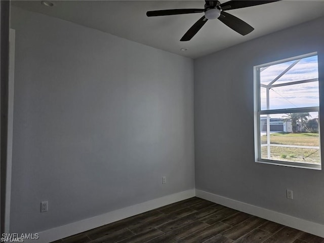 empty room featuring ceiling fan, dark wood-type flooring, and a wealth of natural light