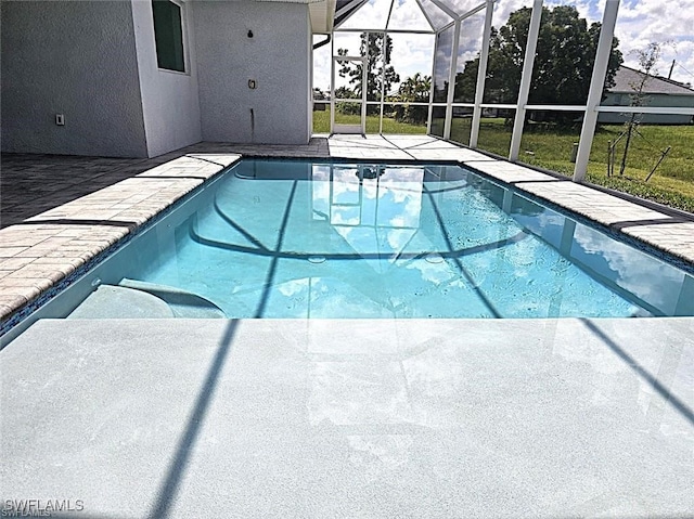 view of swimming pool featuring a patio area and glass enclosure