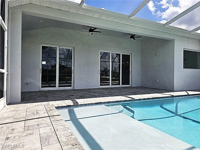 view of pool with a patio area, glass enclosure, and ceiling fan