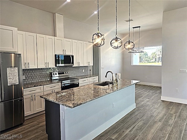 kitchen with sink, white cabinetry, hanging light fixtures, and stainless steel appliances