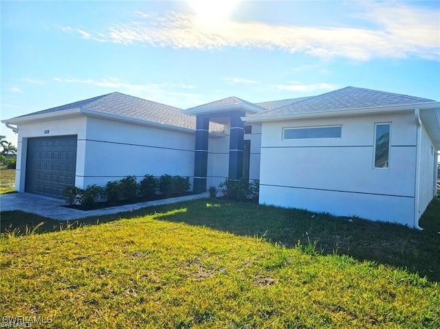 view of front of property featuring a front lawn and a garage