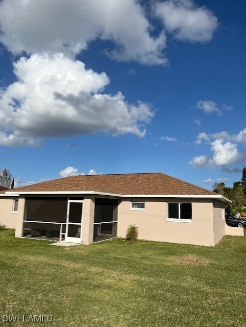 back of property with a yard and a sunroom