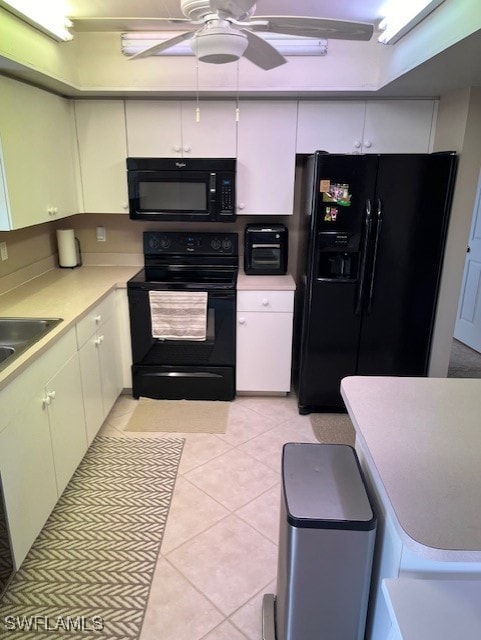 kitchen with black appliances, sink, white cabinetry, ceiling fan, and light tile patterned floors