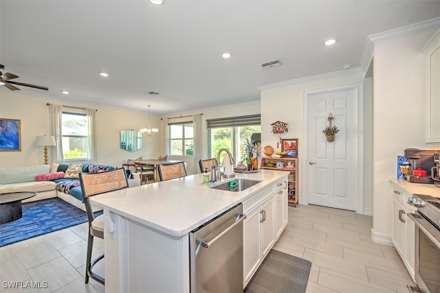 kitchen featuring appliances with stainless steel finishes, a kitchen island with sink, white cabinets, and plenty of natural light