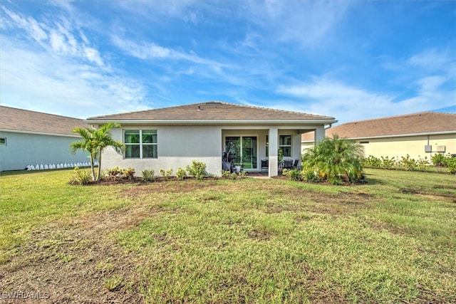 rear view of property featuring a lawn