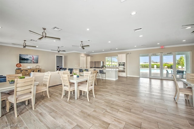 dining area with crown molding, light hardwood / wood-style floors, and french doors