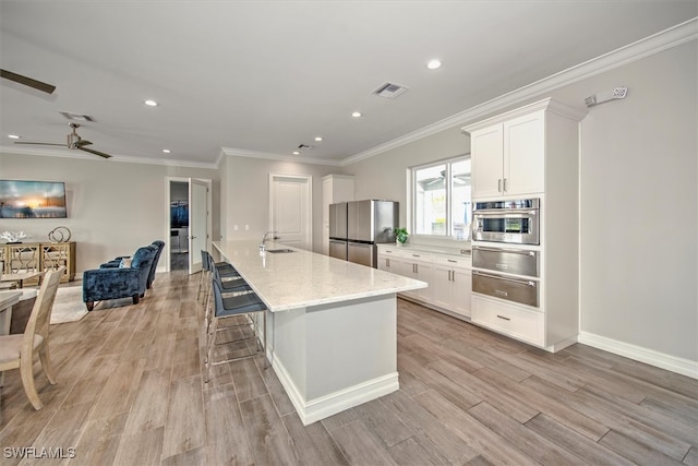 kitchen featuring light hardwood / wood-style floors, white cabinets, and stainless steel appliances