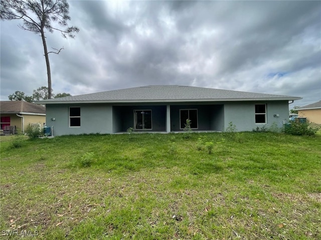 5116/5118 29th St SW, Lehigh Acres, FL 33973 - rear view of property with stucco siding and a yard