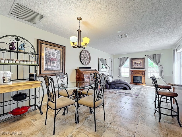 dining area with a chandelier and a textured ceiling