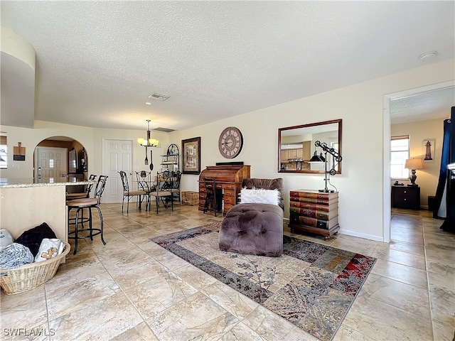 living room featuring a textured ceiling and a notable chandelier