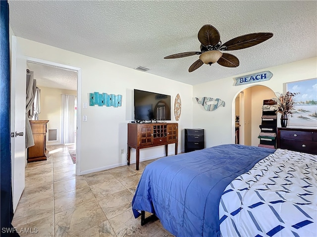 bedroom with ceiling fan and a textured ceiling