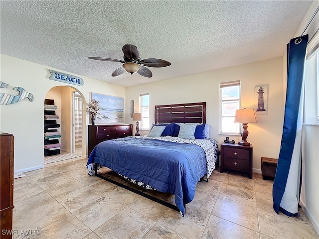 bedroom with ceiling fan and a textured ceiling