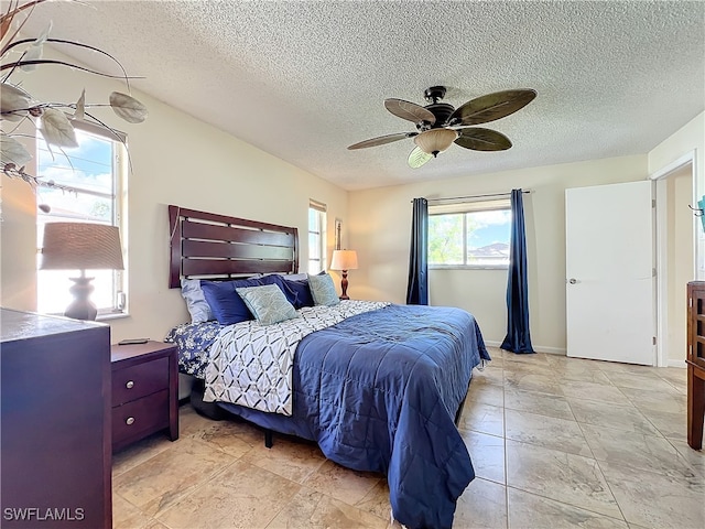 bedroom with a textured ceiling and ceiling fan