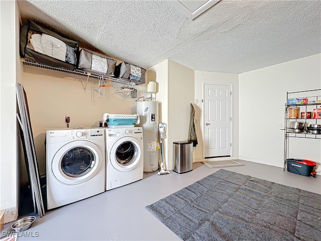 washroom featuring washing machine and dryer, a textured ceiling, and water heater