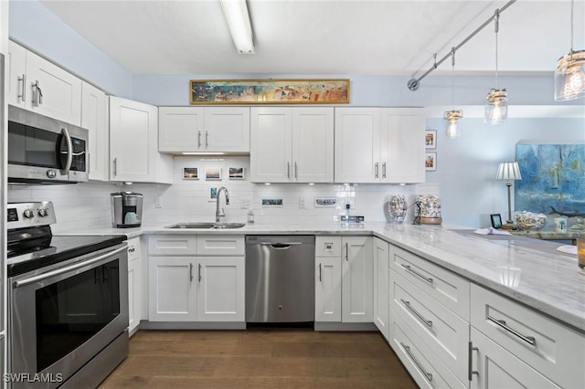 kitchen with white cabinets, decorative backsplash, a sink, and appliances with stainless steel finishes
