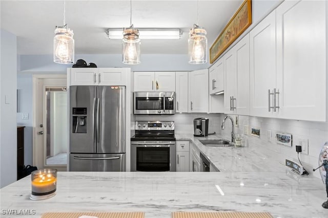kitchen featuring white cabinets, a sink, backsplash, light stone countertops, and appliances with stainless steel finishes