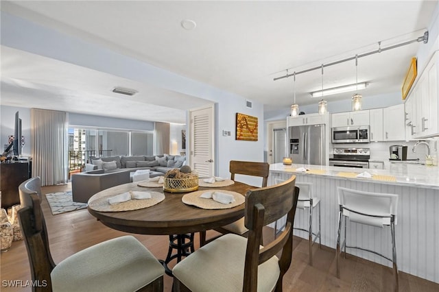 dining space with wood finished floors and visible vents