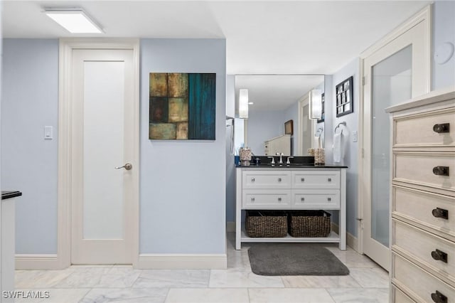 interior space with marble finish floor, baseboards, and a sink