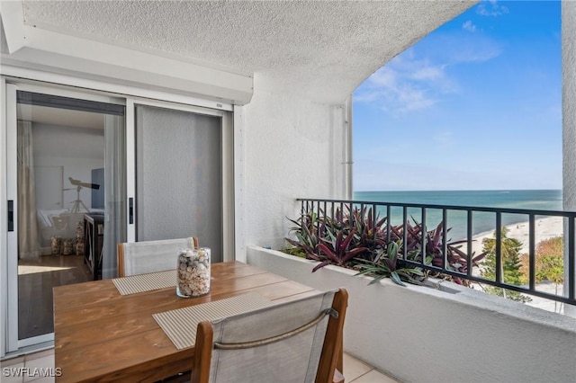 balcony featuring a beach view and a water view