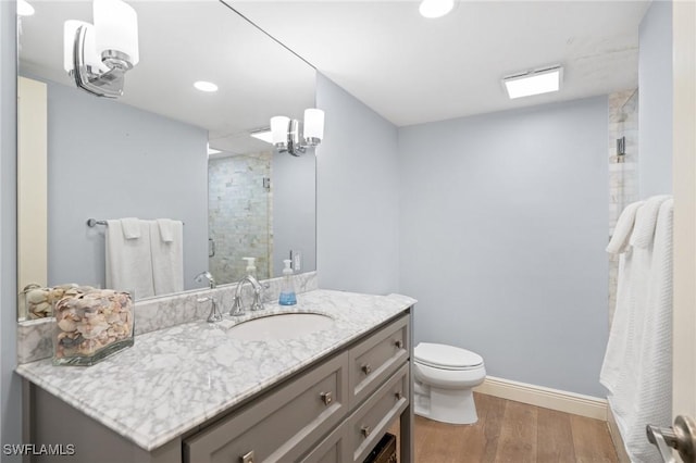 bathroom featuring an inviting chandelier, vanity, wood-type flooring, toilet, and walk in shower