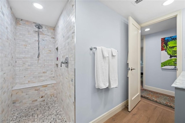 full bathroom with visible vents, wood finished floors, recessed lighting, and tiled shower