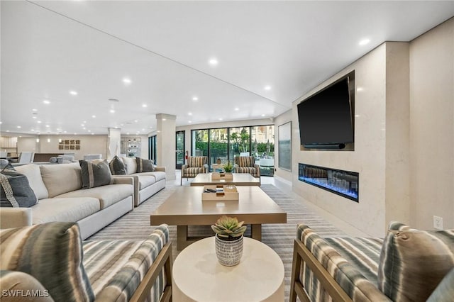 living area with a glass covered fireplace and recessed lighting
