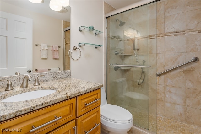 bathroom with toilet, walk in shower, and vanity