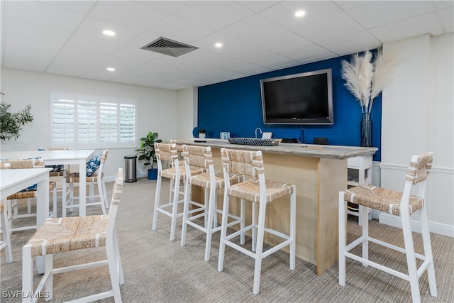 bar with a drop ceiling and light carpet