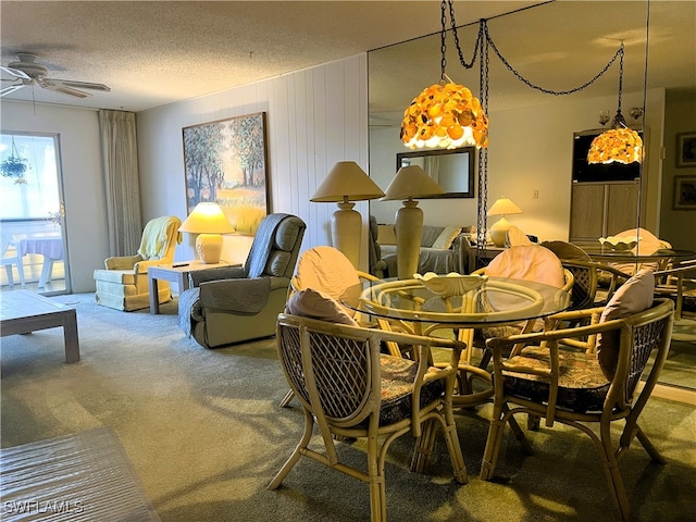 carpeted dining space with a textured ceiling and ceiling fan