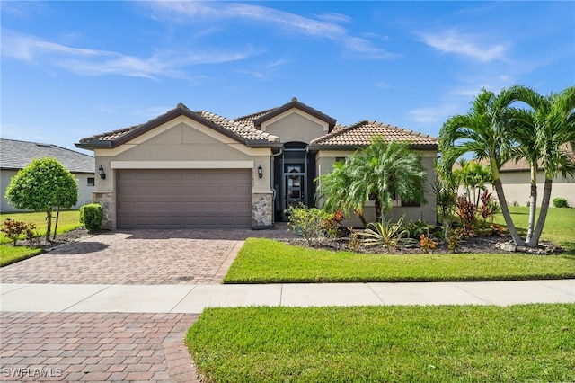 mediterranean / spanish home featuring a front yard and a garage