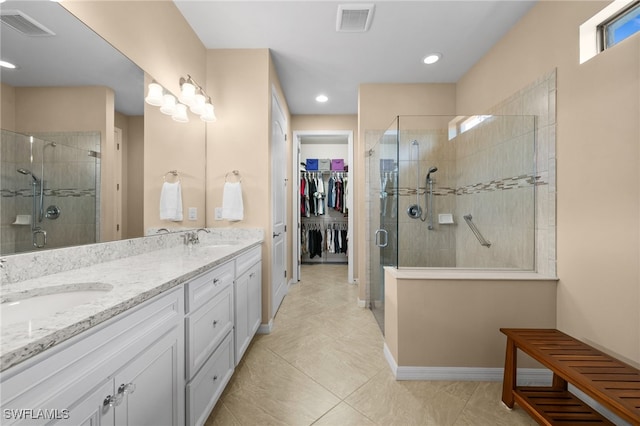 bathroom featuring tile patterned floors, vanity, and a shower with shower door